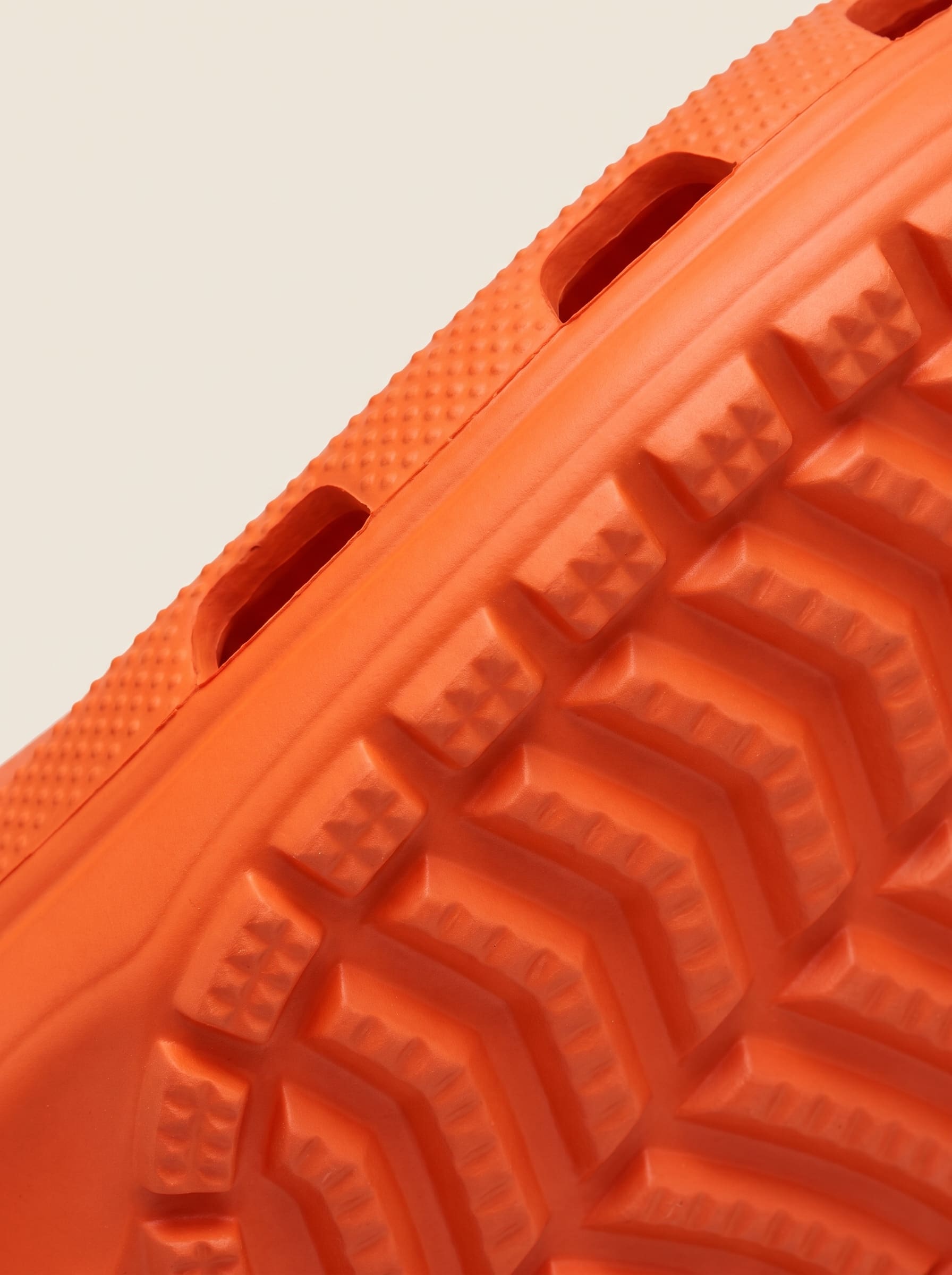 Macro of a safety orange moulded outsole showing lug geometry and a parting seam.