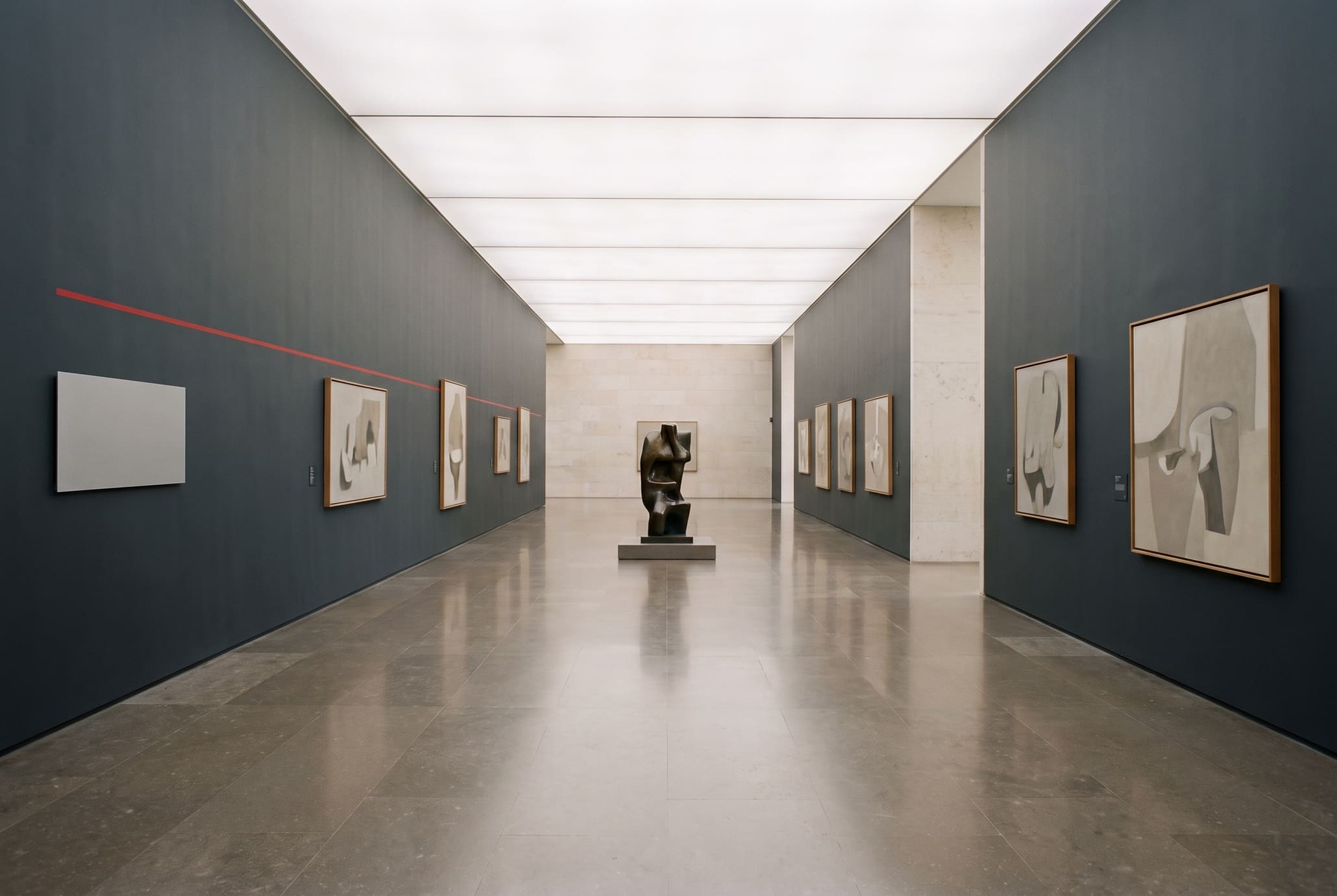 Long grey museum hall in one-point perspective with abstract paintings and one bronze sculpture