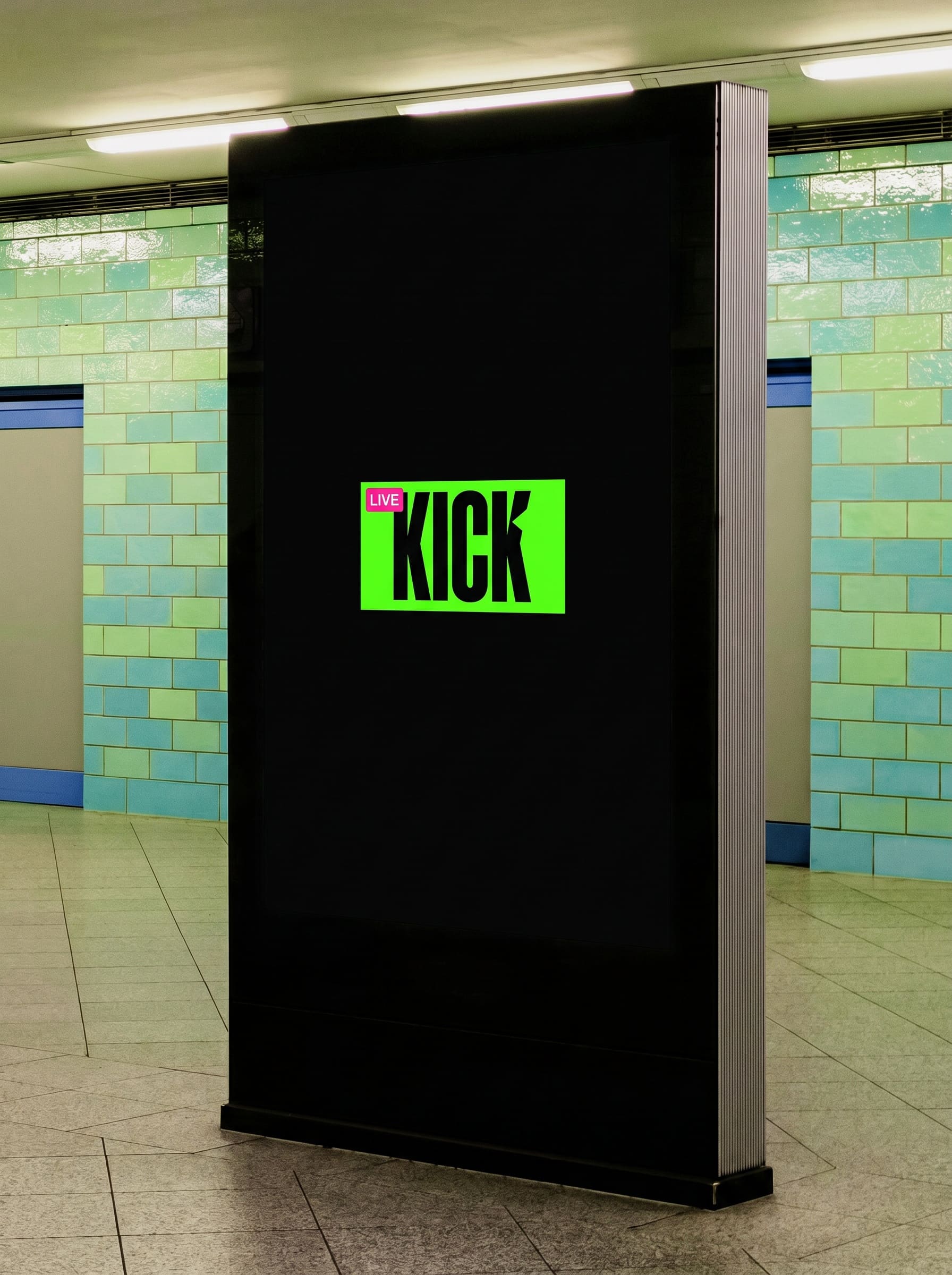 Digital advertising totem in a tiled subway station, its black screen holding one tiny green thumbnail.