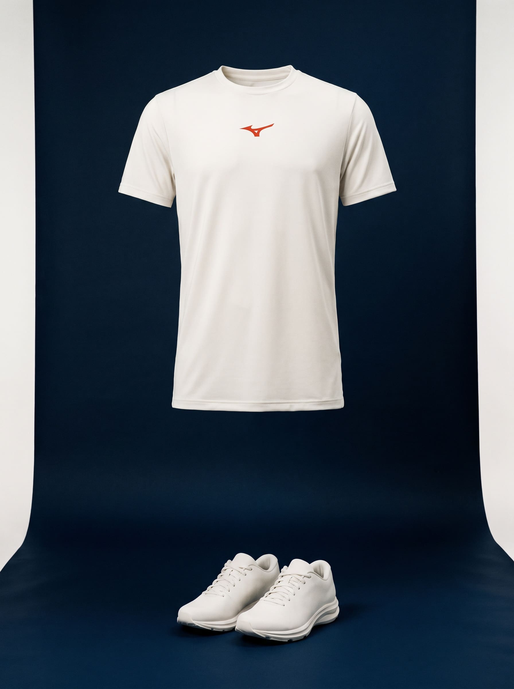 Ghost-mannequin running top and shoes on deep blue seamless in bone and graphite, marked once in vermilion.