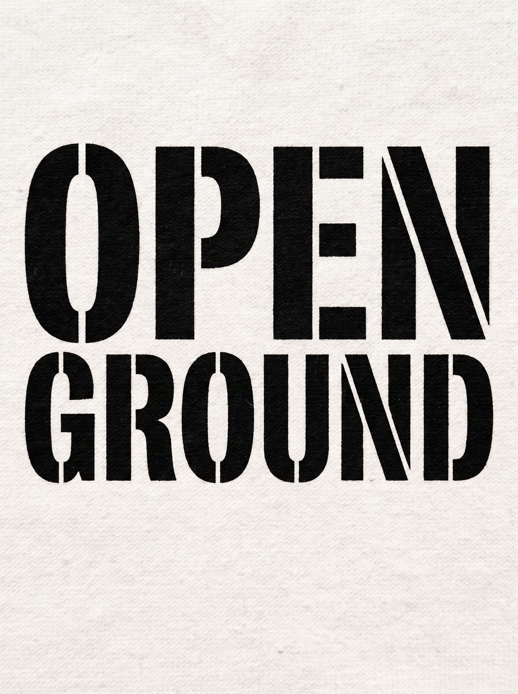 Macro of black stencil type OPEN GROUND printed on cotton