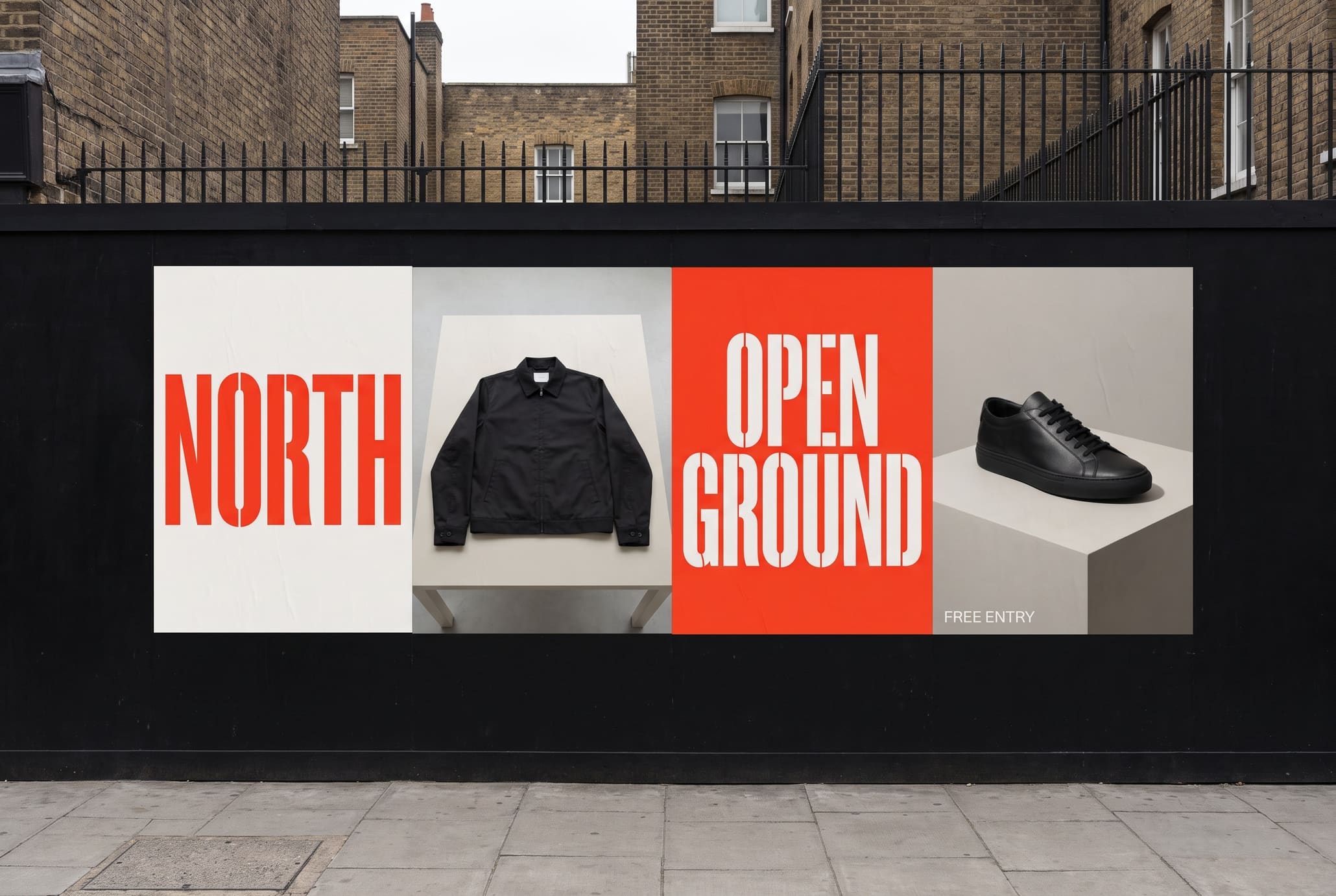 Black street hoarding pasted with red, off-white and photographic posters showing a folded jacket and a single shoe on a plinth