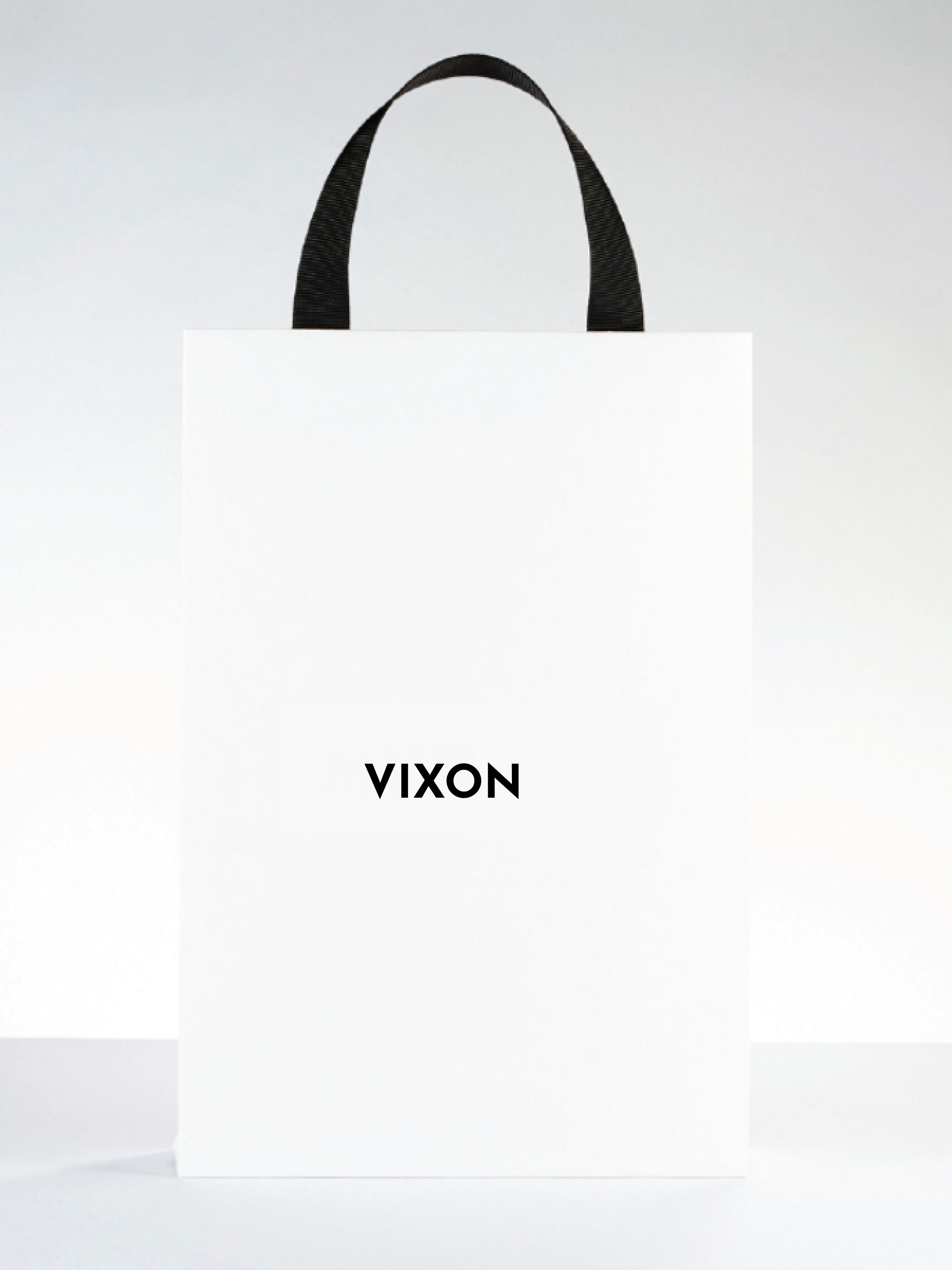 A white shopping bag with black handles and a small centered Vixon wordmark